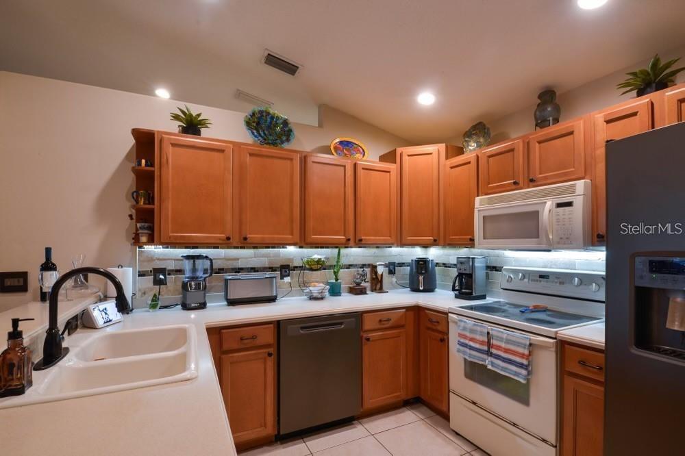 11347 Walden Loop Parrish, FL 34219 - Photo 7 of 29 a kitchen with stainless steel appliances a sink stove and cabinets