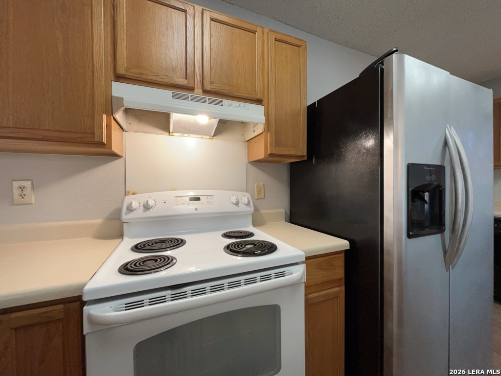 7322 Raintree Forest San Antonio, TX 78233 - Photo 15 of 40 a kitchen with a stove and a refrigerator
