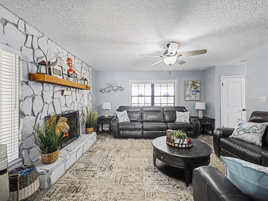 24420 Lanark Road Brooksville, FL 34601 - Photo 13 of 56 a living room with furniture and a fireplace