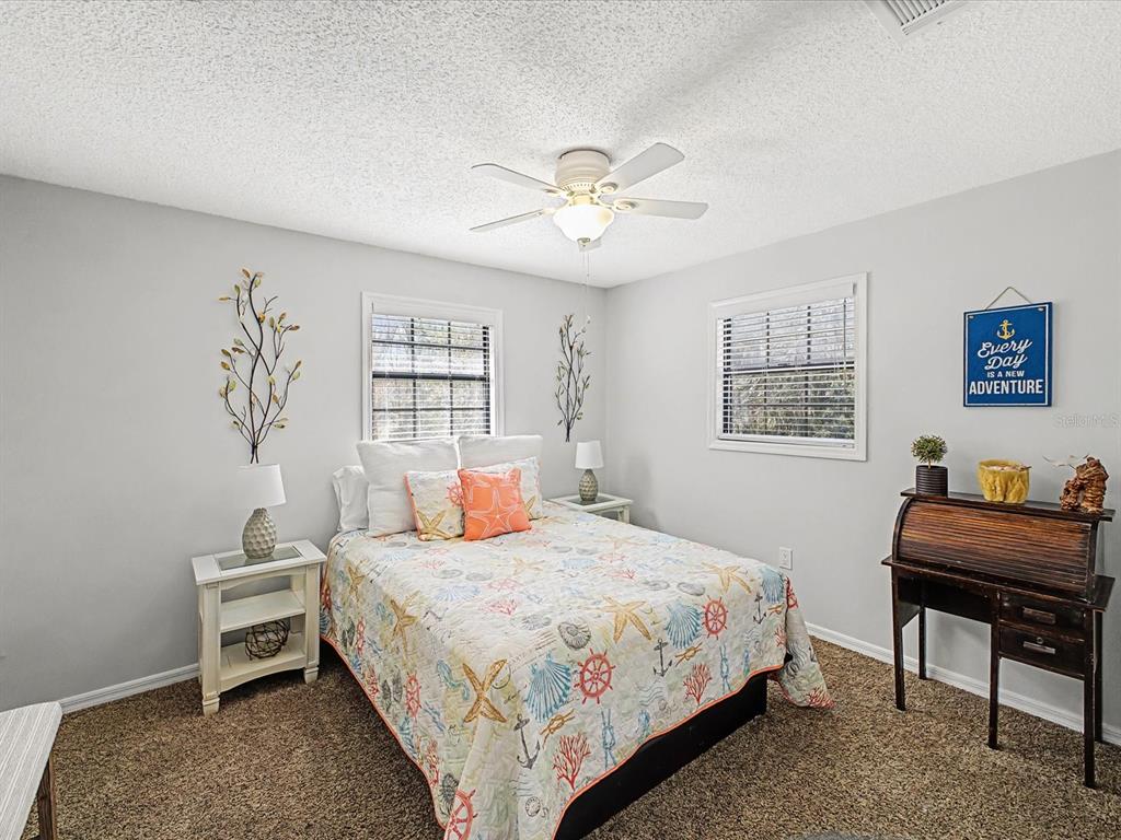 24420 Lanark Road Brooksville, FL 34601 - Photo 24 of 56 a bedroom with a bed and a table in it