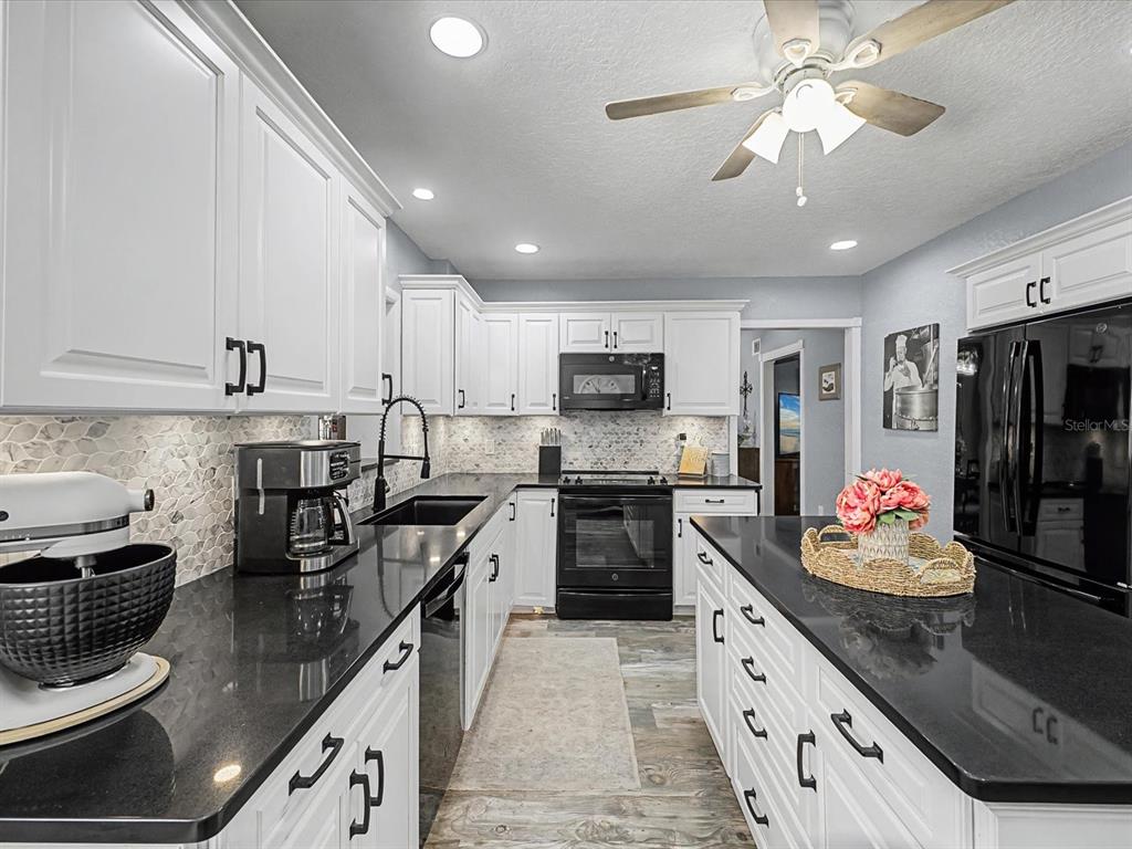 24420 Lanark Road Brooksville, FL 34601 - Photo 3 of 56 a kitchen with granite countertop stainless steel appliances lots of counter top space cabinets and a center island