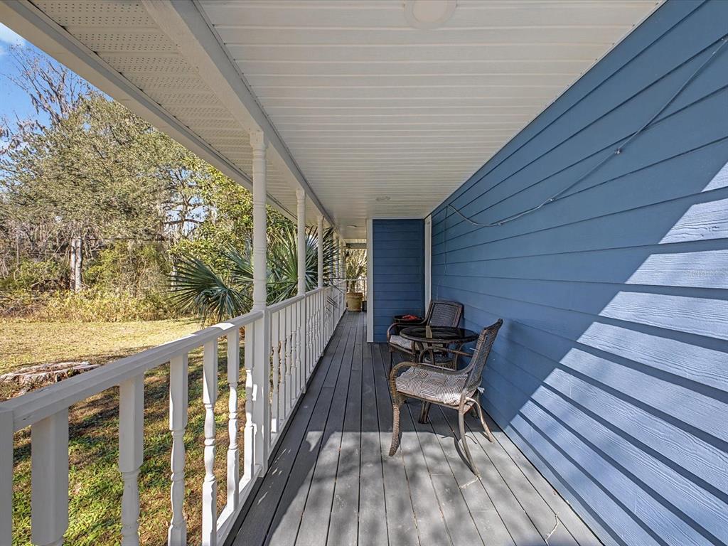 24420 Lanark Road Brooksville, FL 34601 - Photo 33 of 56 a balcony with wooden floor and outdoor seating