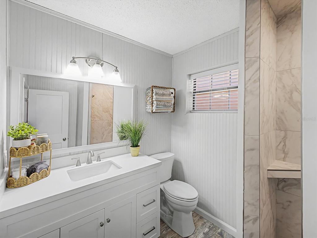 24420 Lanark Road Brooksville, FL 34601 - Photo 5 of 56 a bathroom with a toilet a sink and mirror