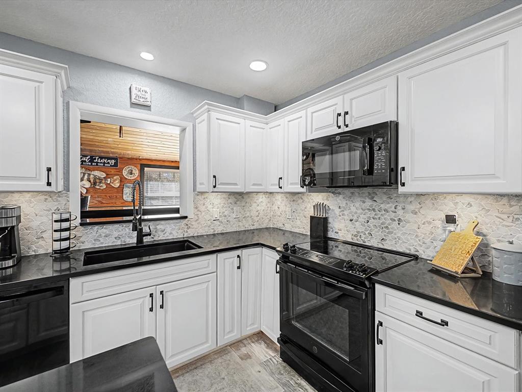 24420 Lanark Road Brooksville, FL 34601 - Photo 7 of 56 a kitchen with stainless steel appliances granite countertop white cabinets granite counter tops and a window