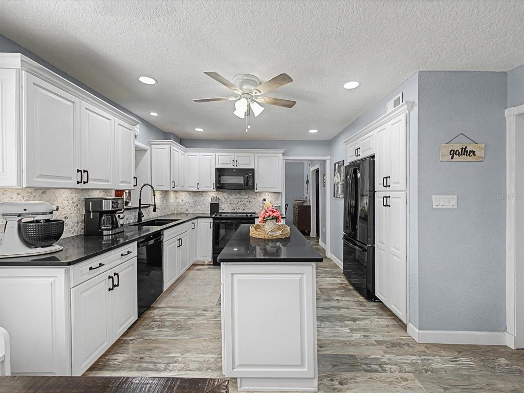 24420 Lanark Road Brooksville, FL 34601 - Photo 8 of 56 a kitchen with a sink stainless steel appliances and white cabinets