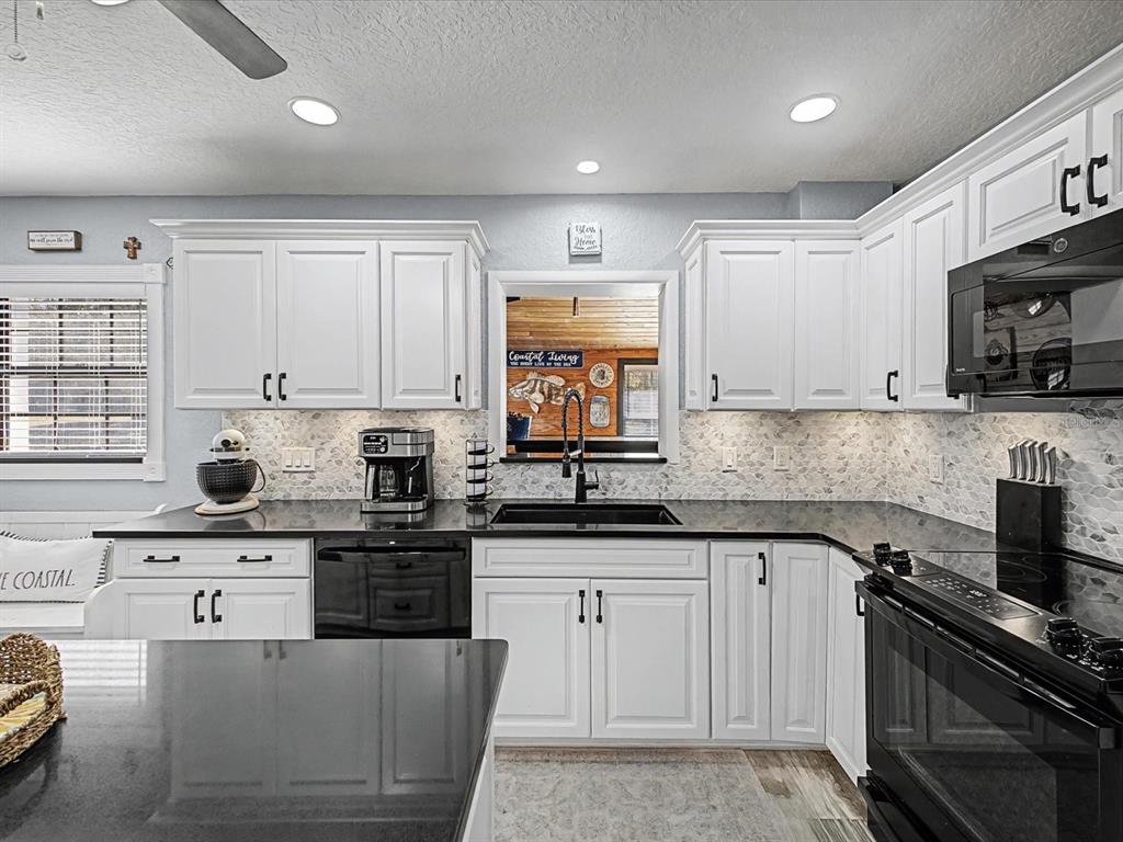 24420 Lanark Road Brooksville, FL 34601 - Photo 10 of 56 a kitchen with stainless steel appliances a stove a sink a stove a microwave and cabinets