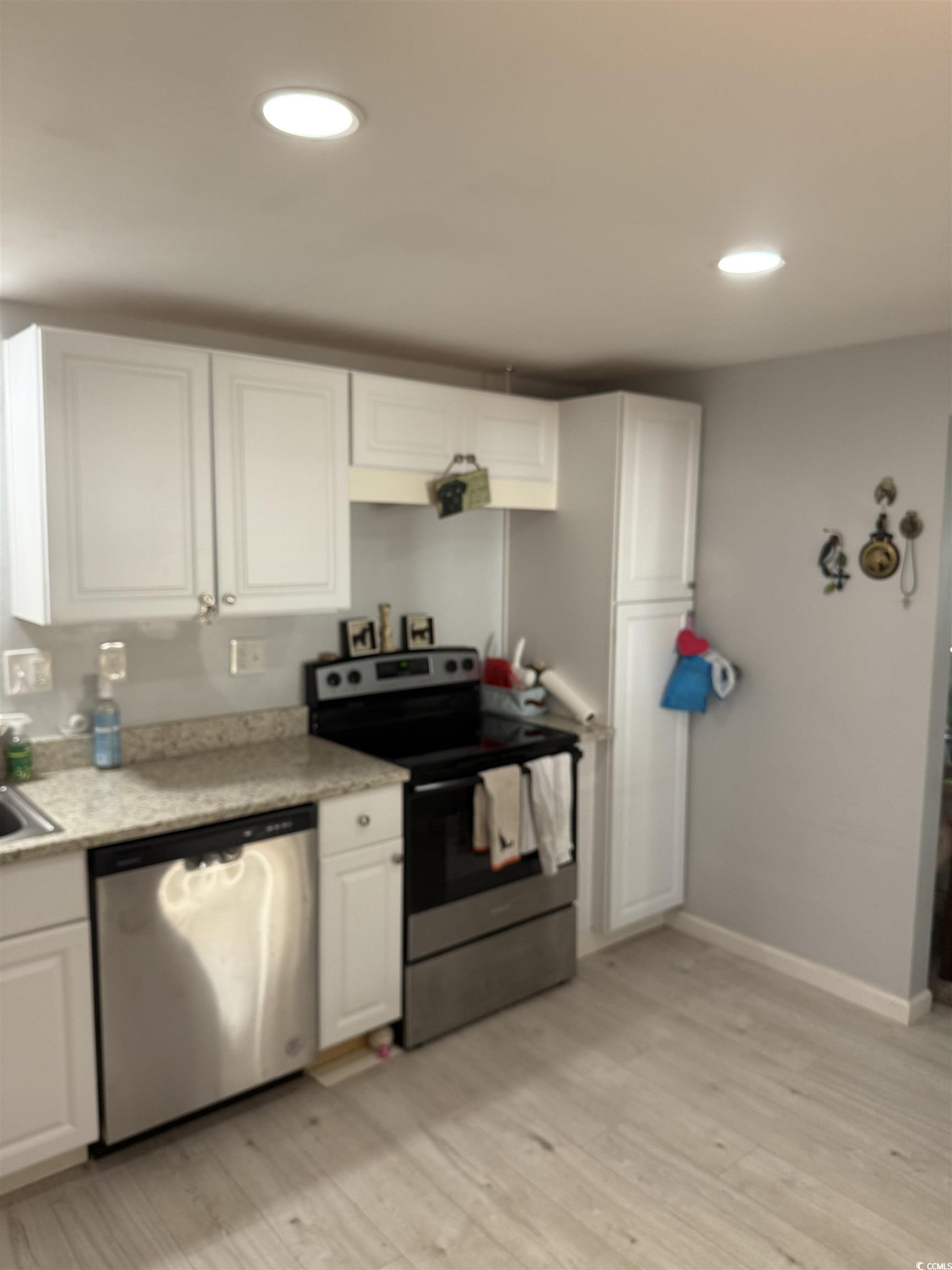 2945 Clemson Trail Murrells Inlet, SC 29576 - Photo 13 of 23 Kitchen featuring appliances with stainless steel finishes, white cabinets, recessed lighting, light wood-style floors, and light stone counters