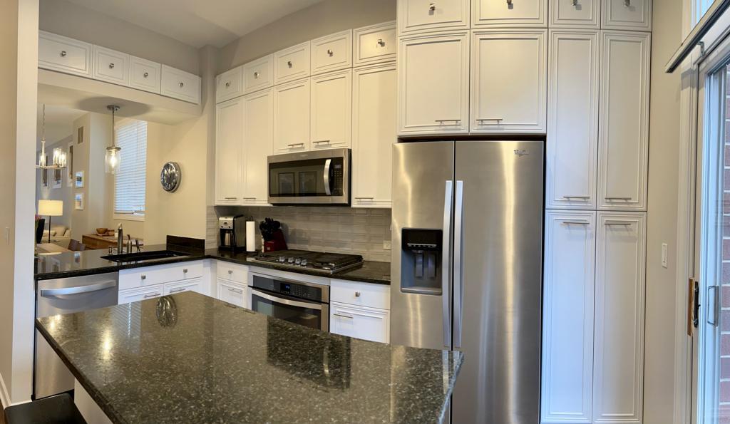 218 East Cullerton Street Chicago, IL 60616 - Photo 15 of 29 a kitchen with stainless steel appliances granite countertop a refrigerator a stove and a sink with wooden floor