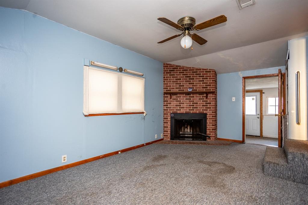 1414 Rice Avenue Gainesville, TX 76240 - Photo 5 of 21 a view of an empty room with a fireplace and a window