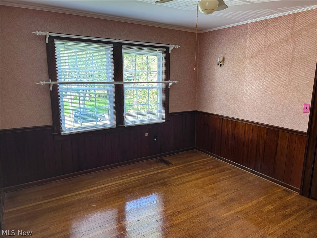 7121 North Lima Road Youngstown, OH 44514 - Photo 30 of 37 Room featuring wood-finish flooring, dark wood paneling, and a double window with blinds