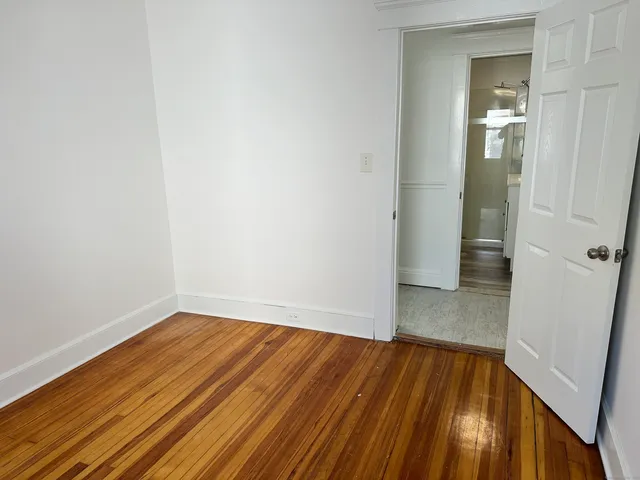 a view of a room with wooden floor and a bathroom