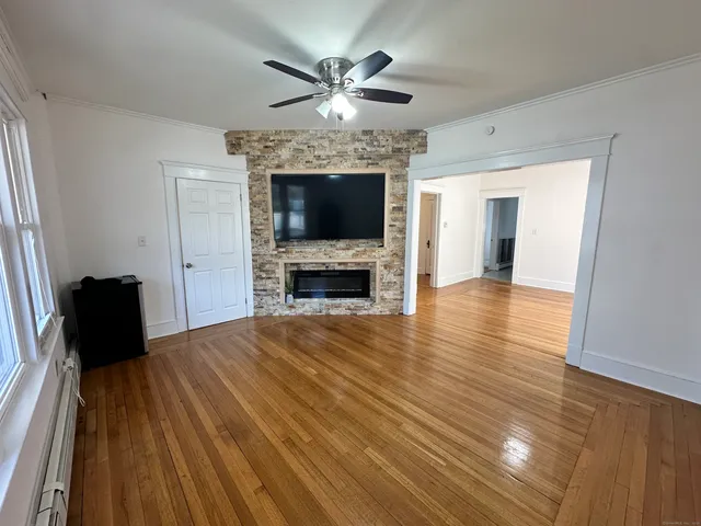 a view of a livingroom with a fireplace a chandelier and wooden floor