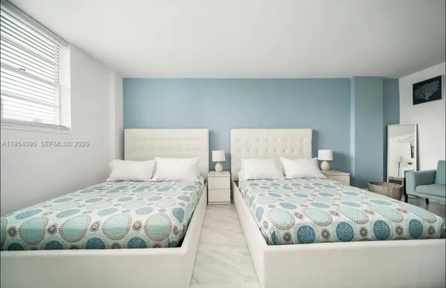 a bedroom with two beds and a window