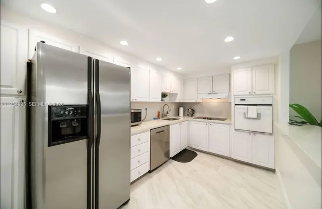 a kitchen with white cabinets and stainless steel appliances
