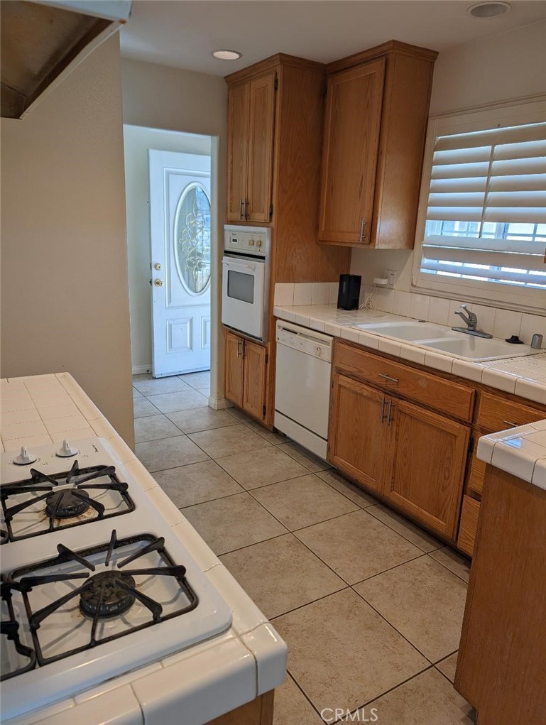 5331 Sunnyside Drive Riverside, CA 92504 - Photo 9 of 25 a kitchen with wooden cabinets a stove top oven a sink and dishwasher