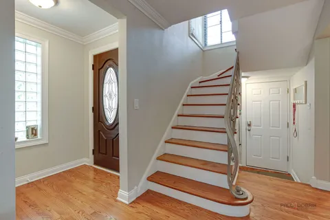 an entryway with wooden floor and windows
