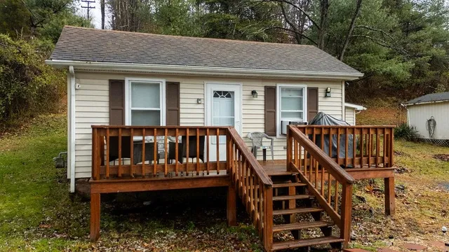 a view of a house with wooden deck and furniture