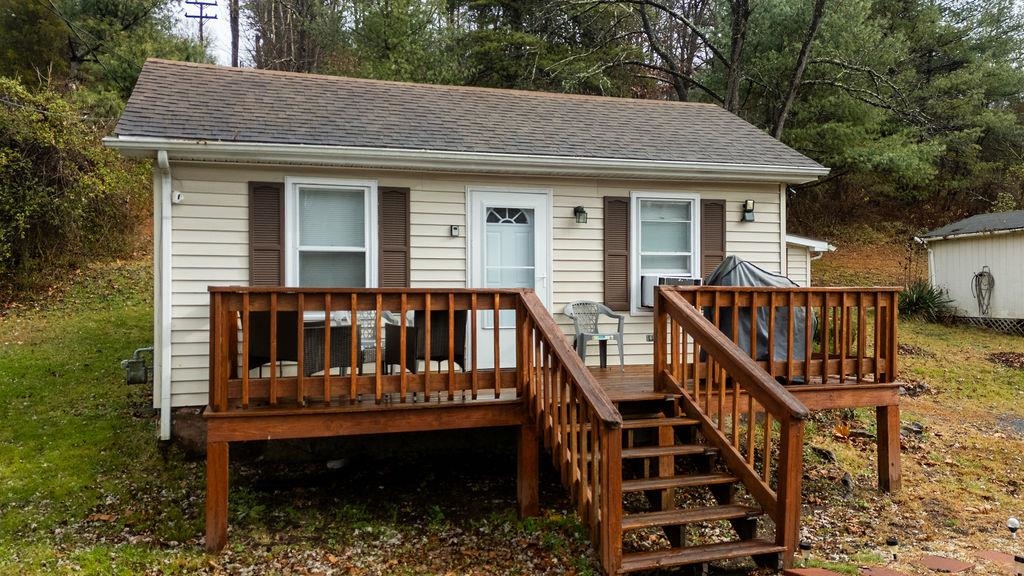 a view of a house with wooden deck and furniture