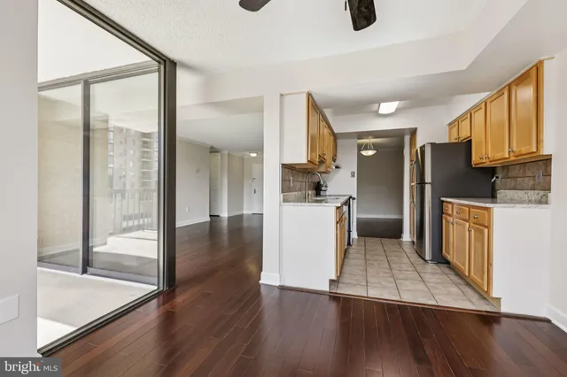 a view of a kitchen with wooden floor and a window