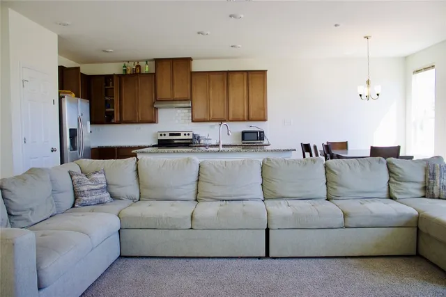 a living room with a couch and a view of kitchen
