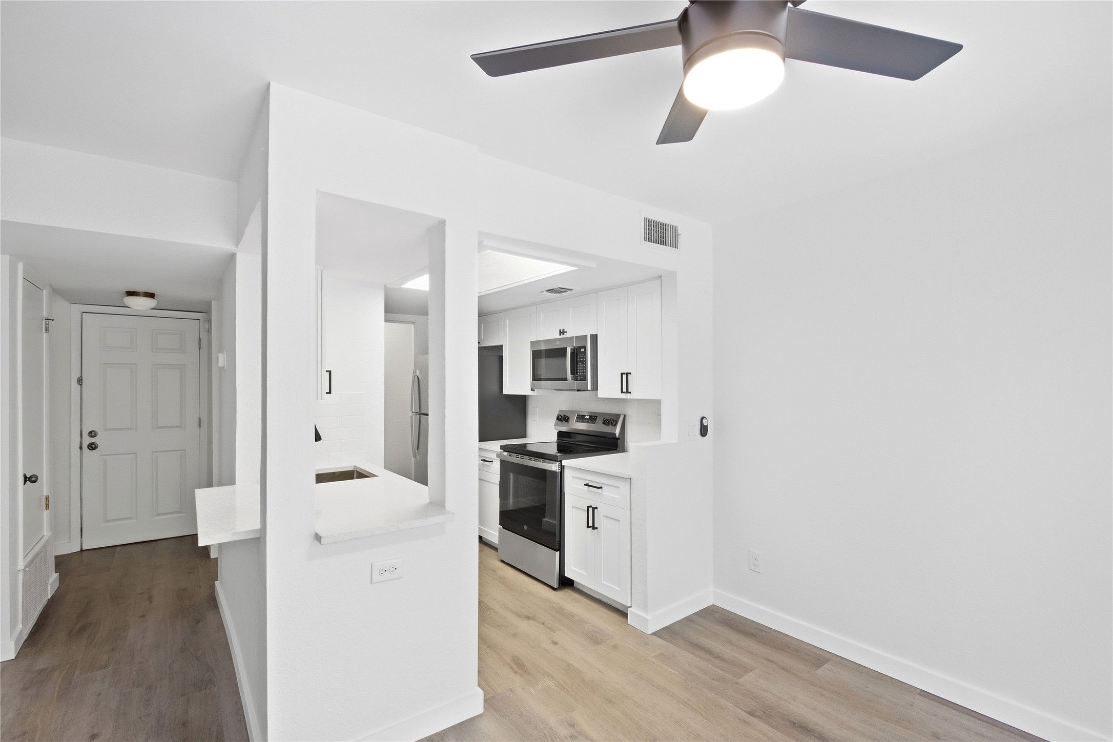 2500 Jones Road, Unit B Austin, TX 78745 - Photo 19 of 37 Smooth wood-style flooring runs through this open layout featuring a kitchen pass-through.