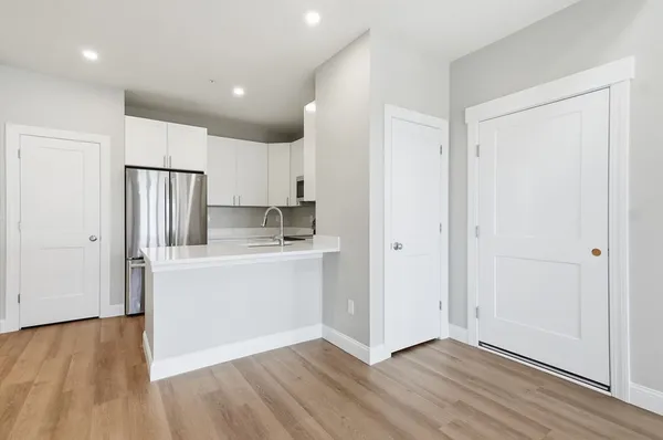 a kitchen with a refrigerator sink and cabinets
