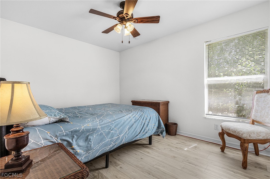 3852 Stabile Road St. James City, FL 33956 - Photo 11 of 27 a bedroom with a bed a chair and a chandelier