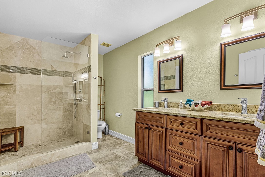 3852 Stabile Road St. James City, FL 33956 - Photo 18 of 27 a bathroom with a double vanity sink mirror and shower