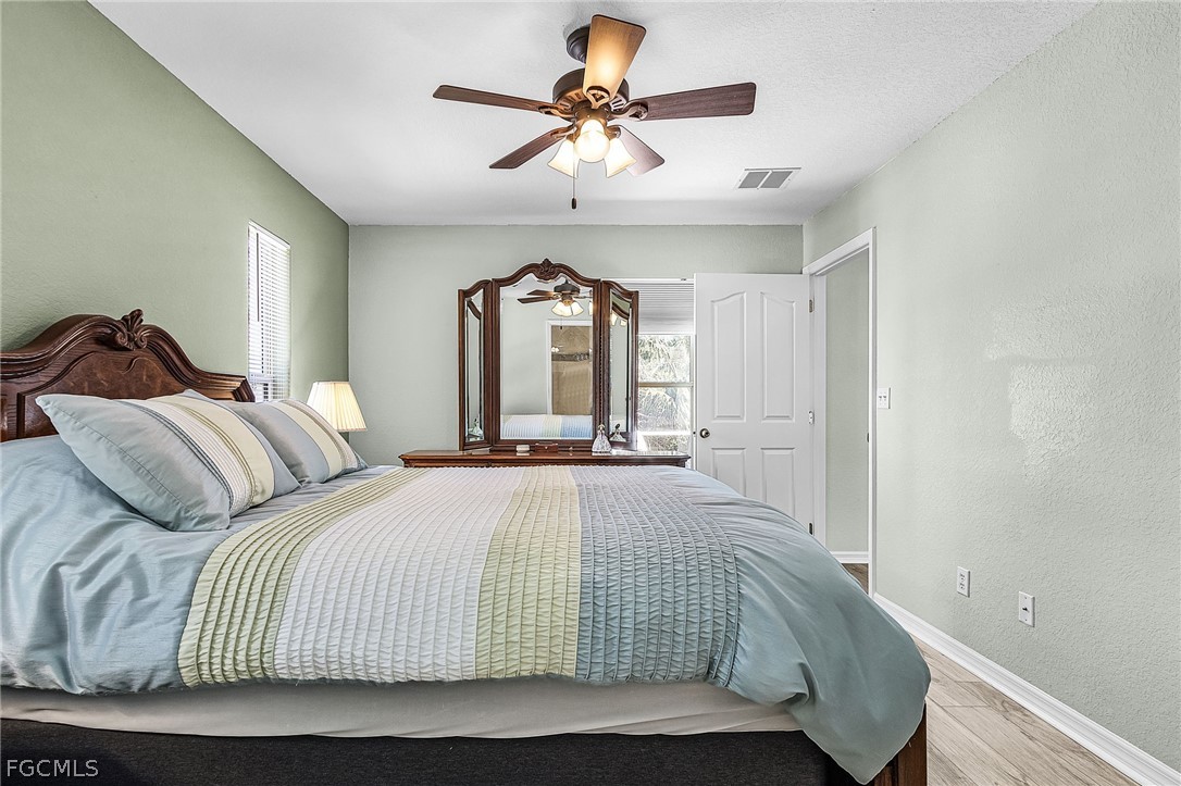 3852 Stabile Road St. James City, FL 33956 - Photo 19 of 27 a bedroom with a bed and ceiling fan