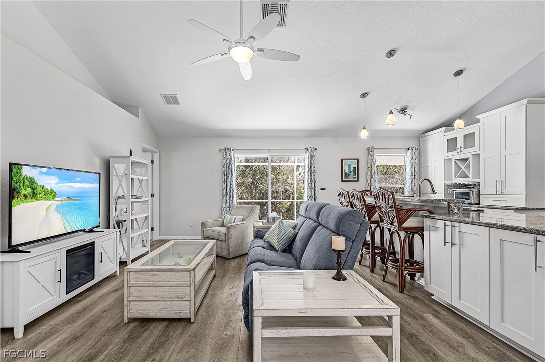 3852 Stabile Road St. James City, FL 33956 - Photo 7 of 27 a living room with furniture a flat screen tv and a fireplace