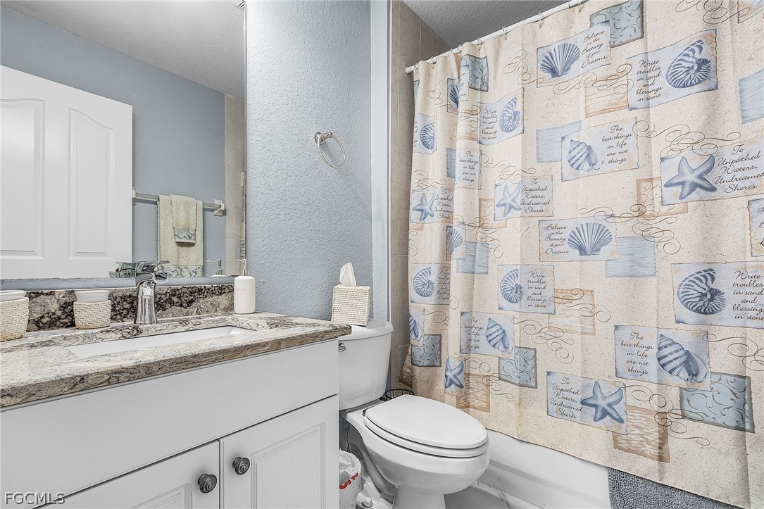 3852 Stabile Road St. James City, FL 33956 - Photo 10 of 27 a bathroom with a granite countertop sink a toilet and a mirror