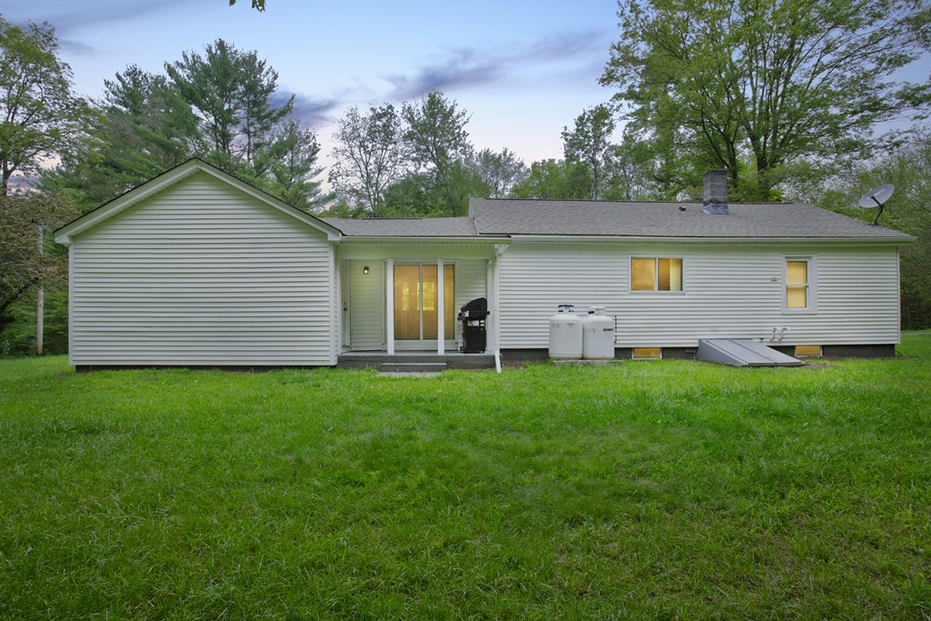 141 Maxwell Road Monson, MA 01057 - Photo 21 of 22 a backyard of a house with potted plants and a large tree