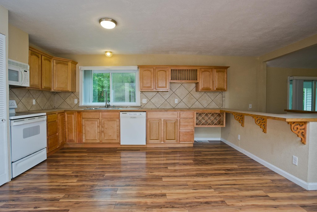 141 Maxwell Road Monson, MA 01057 - Photo 8 of 22 a large kitchen with wooden floors and white cabinets
