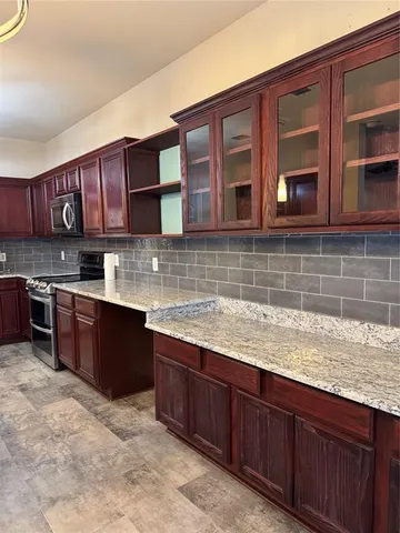 a kitchen with stainless steel appliances granite countertop wooden cabinets a stove top oven a sink and dishwasher