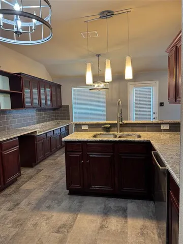 a kitchen with stainless steel appliances granite countertop a sink and wooden cabinets