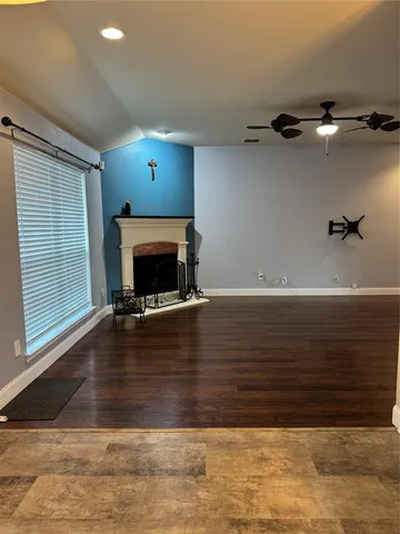 a view of a livingroom with wooden floor and a fireplace