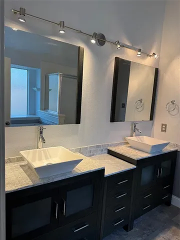 a bathroom with a double vanity sink and a mirror