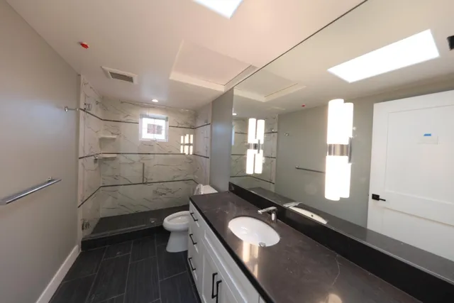a bathroom with a sink a toilet and shower