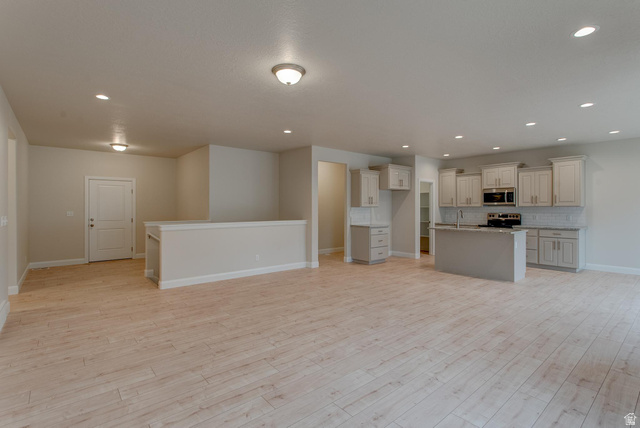 1512 West 600 North, Unit O4A Mapleton, UT 84664 - Photo 22 of 24 Kitchen featuring tasteful backsplash, a kitchen island with sink, recessed lighting, open floor plan, and stainless steel appliances