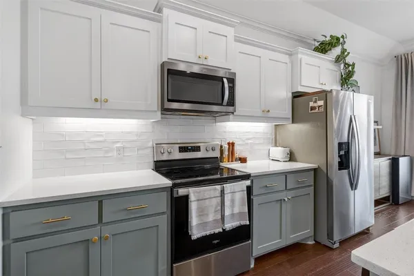 a kitchen with stainless steel appliances a stove microwave and refrigerator