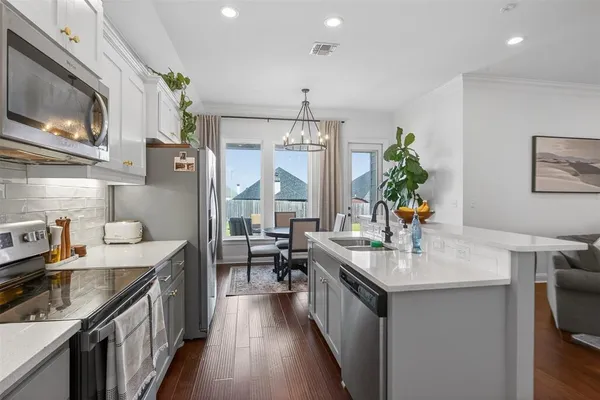 a kitchen with granite countertop a sink stove and cabinets