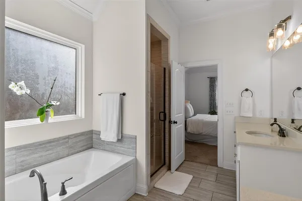 a bathroom with a tub a sink and a window