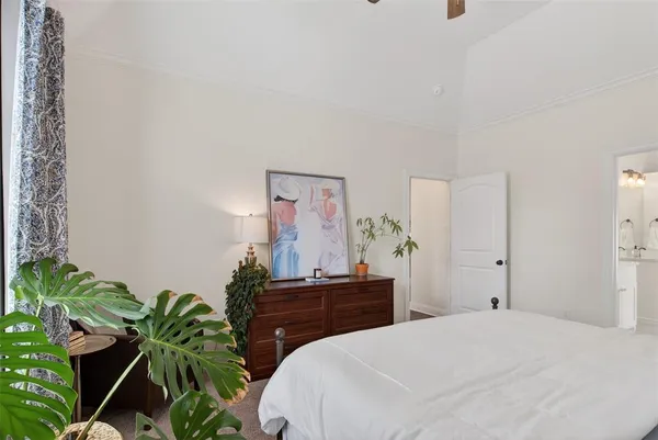 a bedroom with a bed and a potted plant