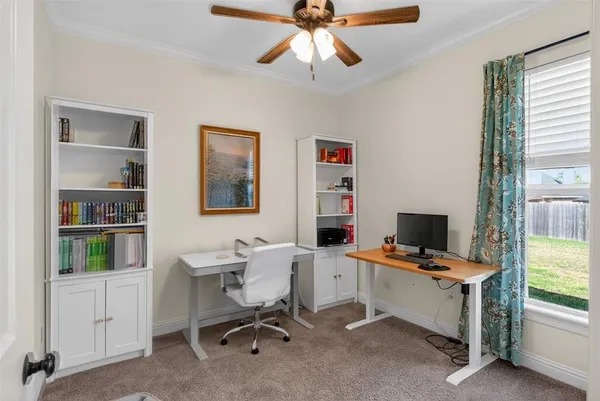 a view of a workspace with furniture and a window