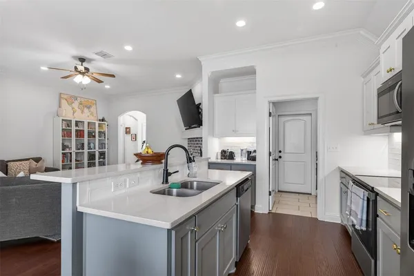 a kitchen with stainless steel appliances a sink and a refrigerator