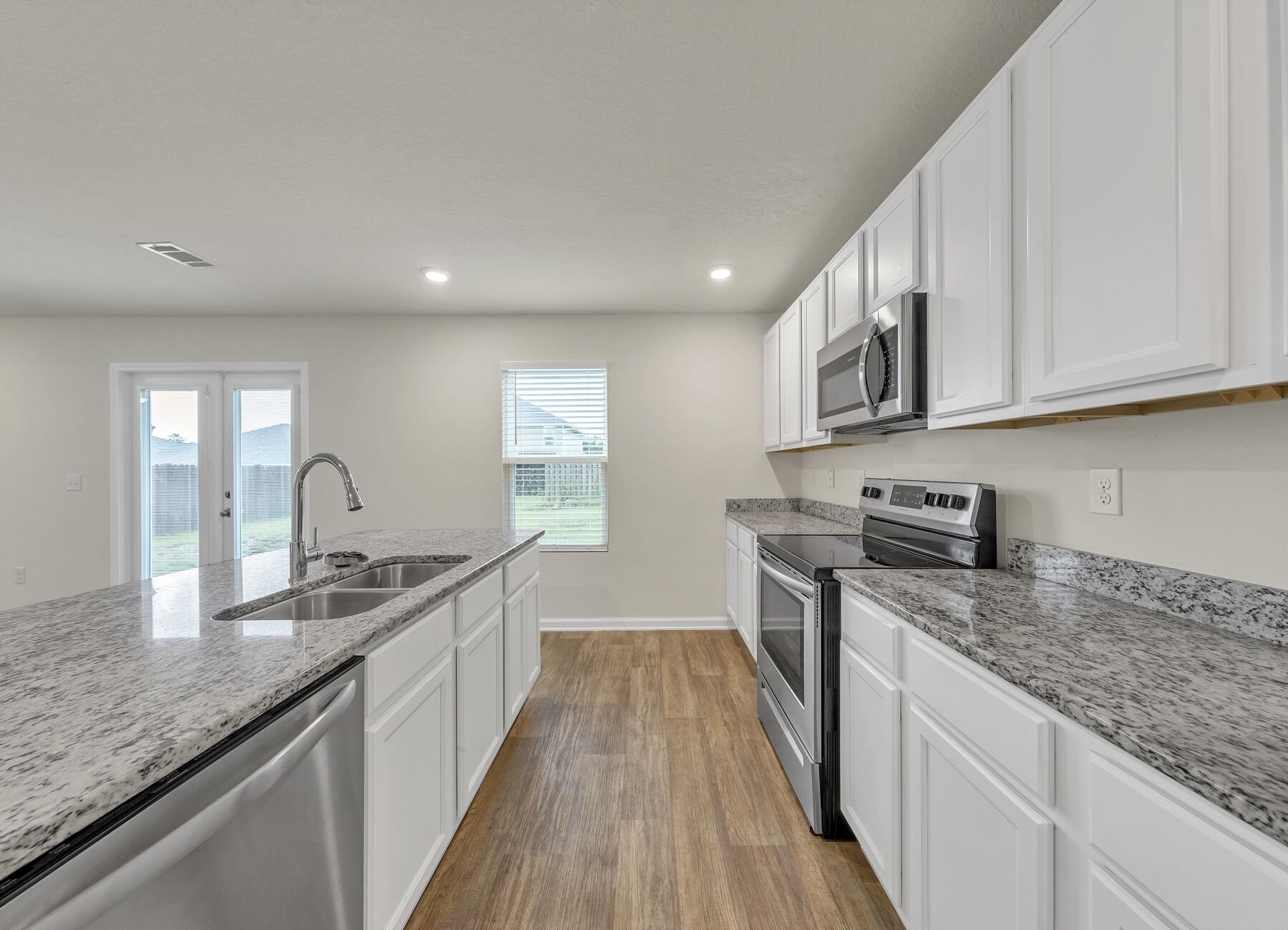 925 Merganser Way Crestview, FL 32539 - Photo 11 of 37 a kitchen with granite countertop a sink stove refrigerator and cabinets
