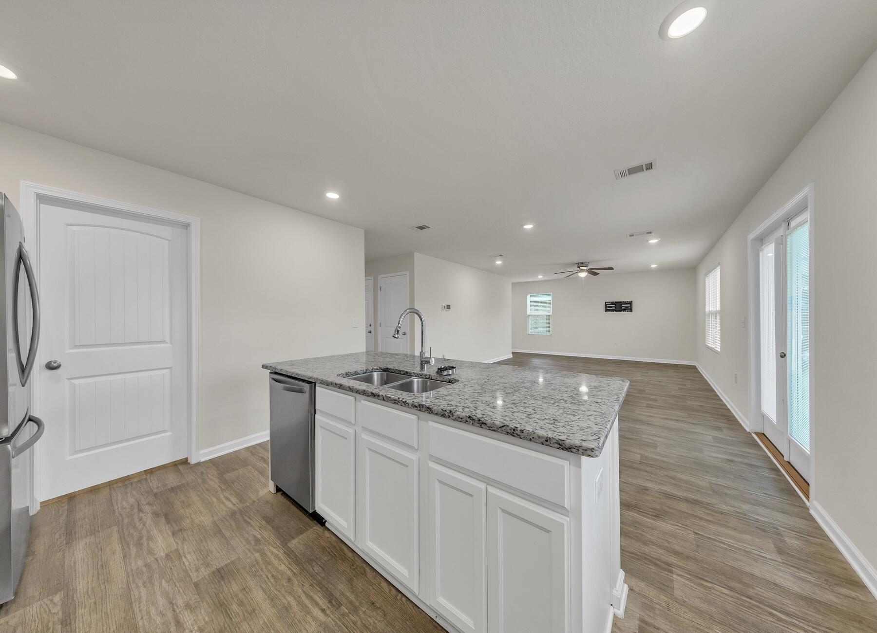 925 Merganser Way Crestview, FL 32539 - Photo 13 of 37 a view of kitchen island a sink wooden floor and a living room