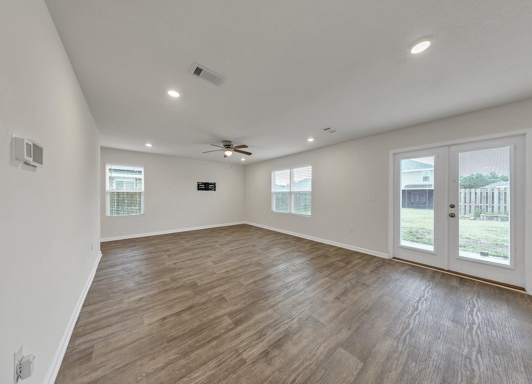 925 Merganser Way Crestview, FL 32539 - Photo 15 of 37 a view of an empty room with wooden floor and a window