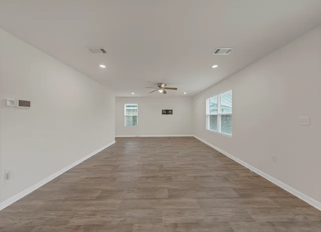 wooden floor in an empty room with a window