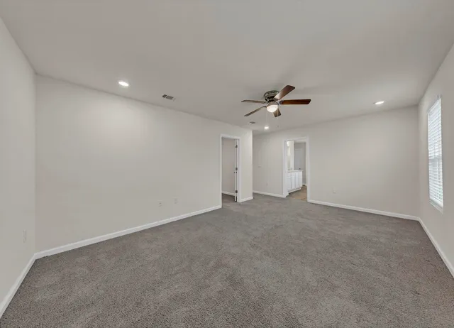 a view of an empty room with a ceiling fan